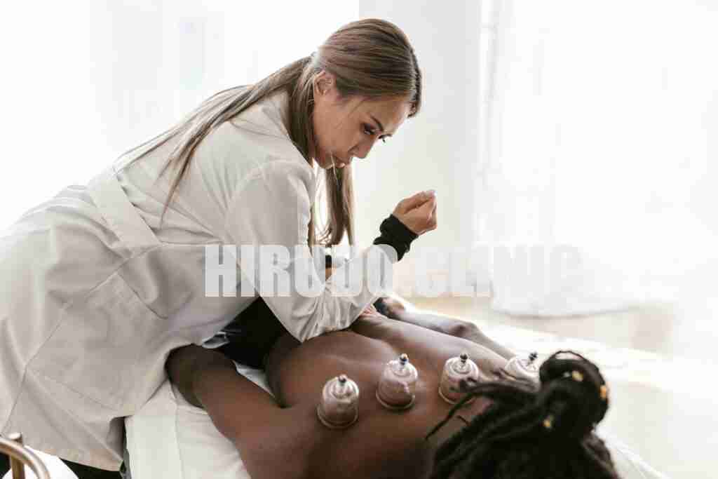 A therapist applies cupping therapy on a patient's back for pain relief and wellness.