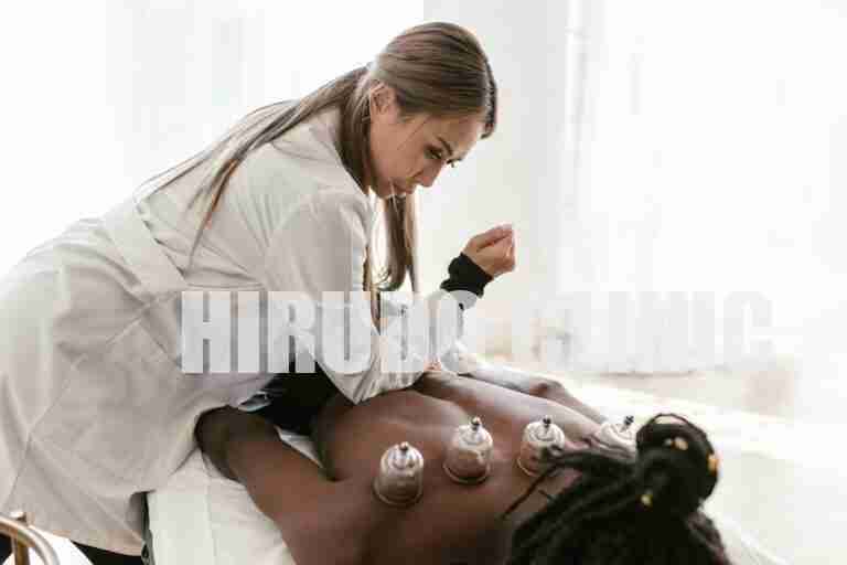 A therapist applies cupping therapy on a patient's back for pain relief and wellness.